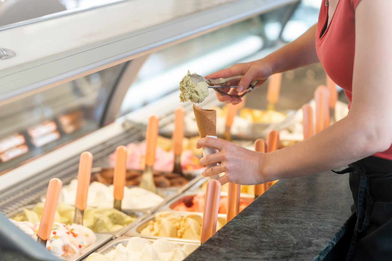 Ice cream showcase with a saleswoman preparing an ice cream cone